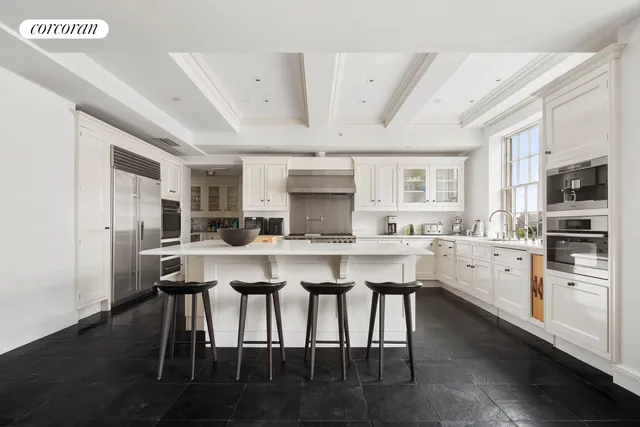 a kitchen with stainless steel appliances white cabinets and wooden floor