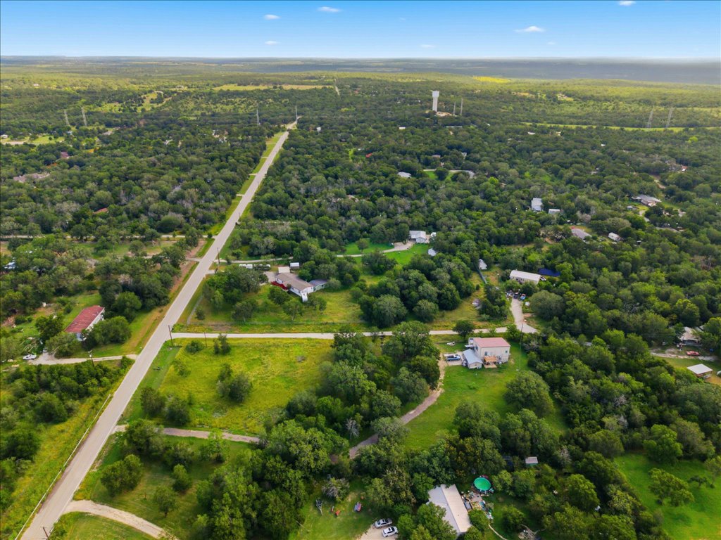 211 Webberwood Way Elgin, TX 78621 - Photo 3 of 10 An aerial perspective reveals a vast expanse of verdant landscapes, punctuated by winding roads and secluded homes.