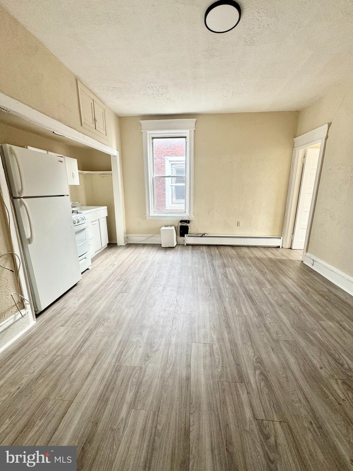 5040 Walnut Street, Unit 3R Philadelphia, PA 19139 - Photo 2 of 9 an empty room with wooden floor and windows