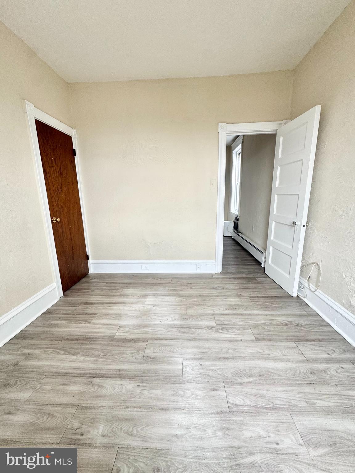 5040 Walnut Street, Unit 3R Philadelphia, PA 19139 - Photo 4 of 9 a view of an empty room with wooden floor and closet