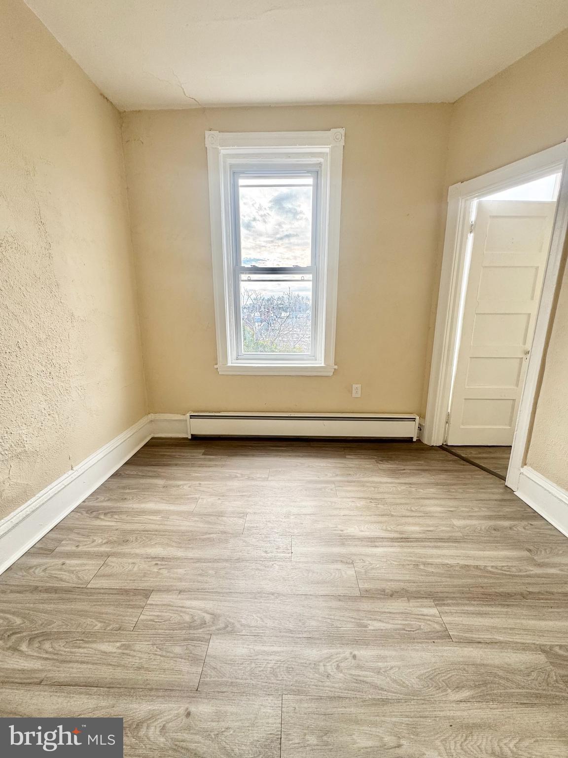 5040 Walnut Street, Unit 3R Philadelphia, PA 19139 - Photo 5 of 9 an empty room with wooden floor and windows
