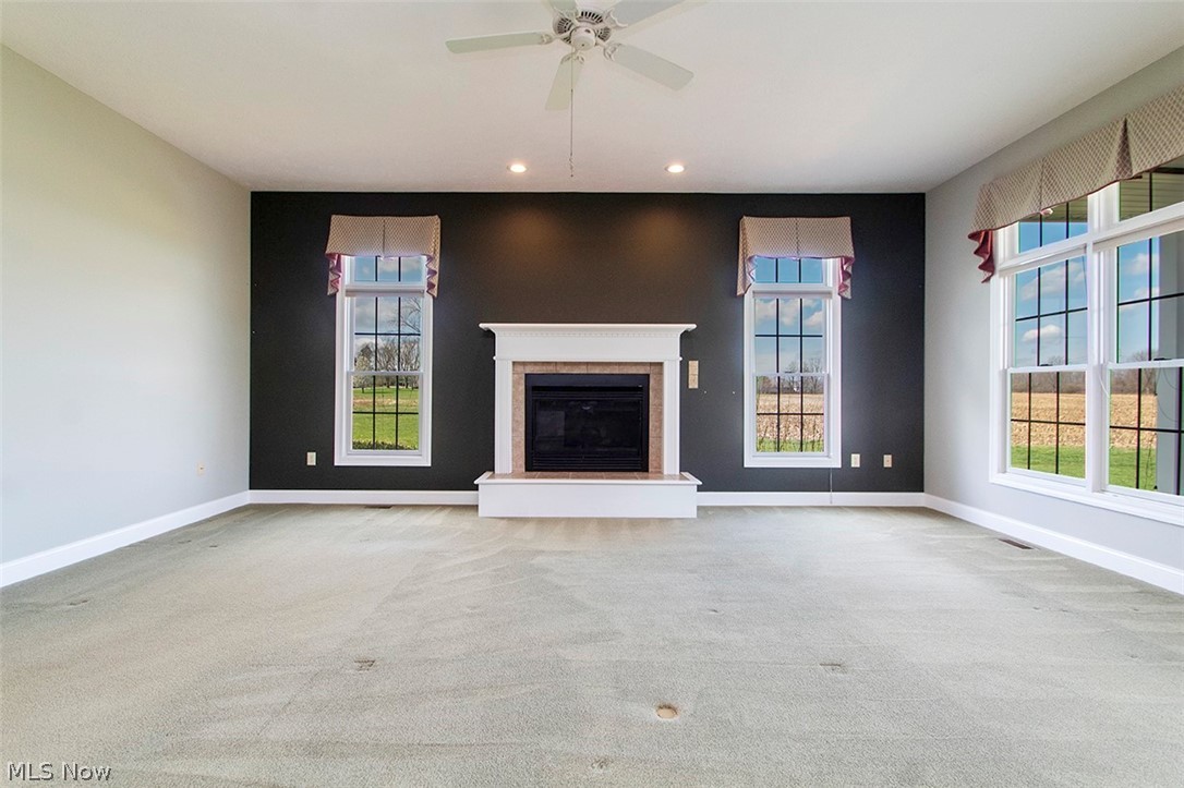 2201 Granger Road Medina, OH 44256 - Photo 9 of 34 Great room with light carpet, ceiling fan, a glass covered fireplace, and recessed lighting
