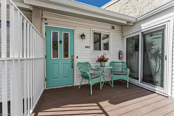 a view of a porch with a table and chairs