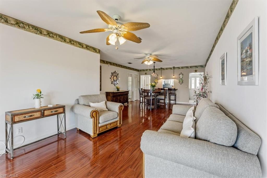 492 Bristle Cone Lane, Unit 47 Naples, FL 34113 - Photo 7 of 21 a living room with furniture and a chandelier