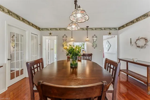 a dining room with furniture a chandelier and wooden floor