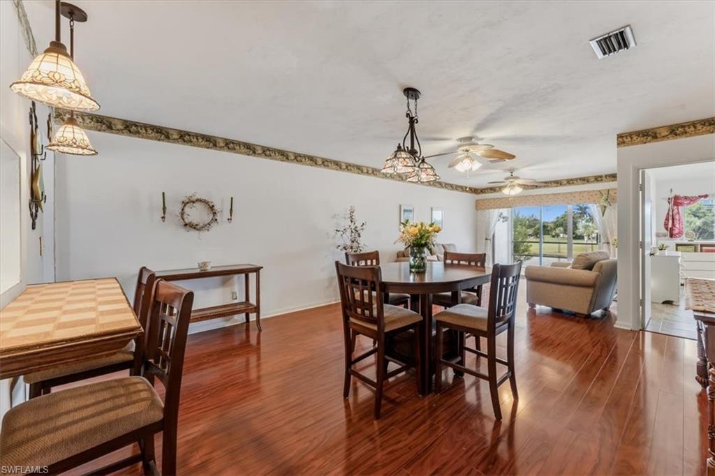 492 Bristle Cone Lane, Unit 47 Naples, FL 34113 - Photo 9 of 21 a view of a dining room with furniture and wooden floor