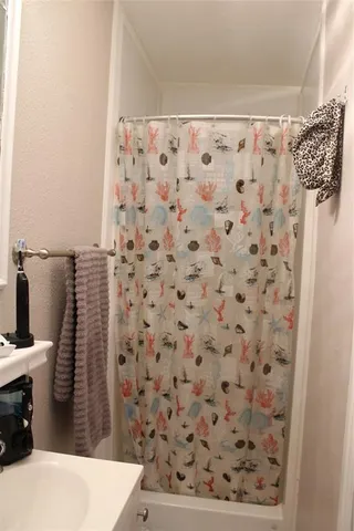 a bathroom with a shower curtain and a sink