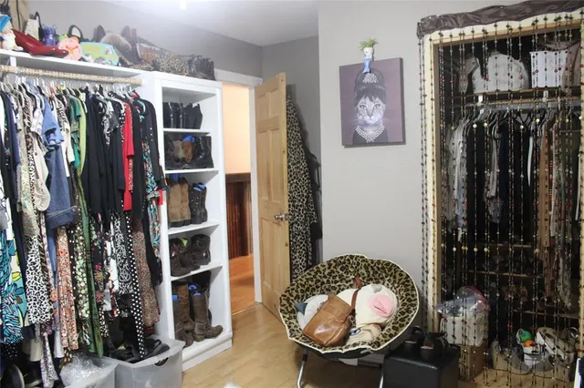 a view of walk in closet with clothes and shoes