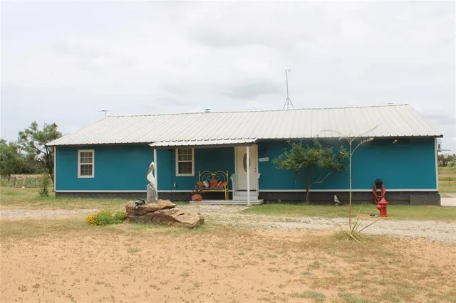 a backyard of a house with barbeque oven table and chairs