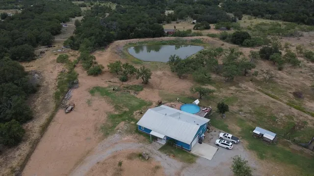 an aerial view of a house with a yard and lake view