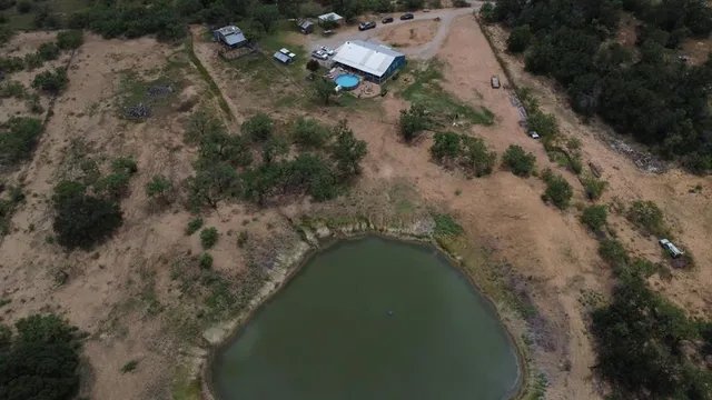 an aerial view of a house with a yard and lake view
