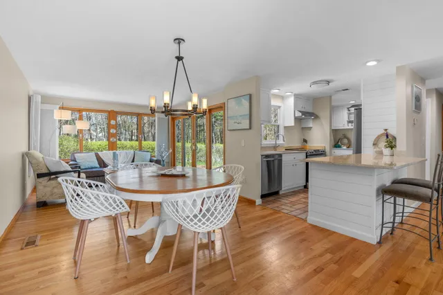 a dining room with furniture a chandelier and wooden floor