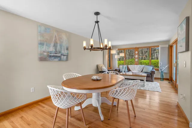 a dining room with furniture a chandelier and wooden floor