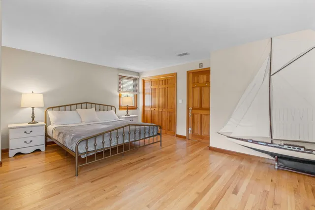 a large bedroom with a bed and wooden floor