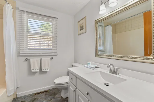 a bathroom with a sink vanity mirror and toilet