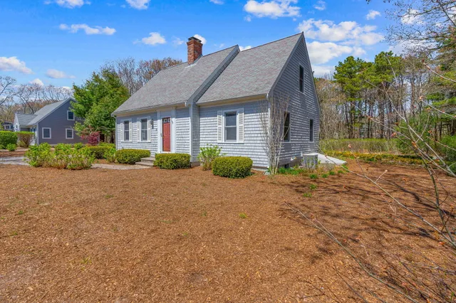 a front view of house with yard and trees around