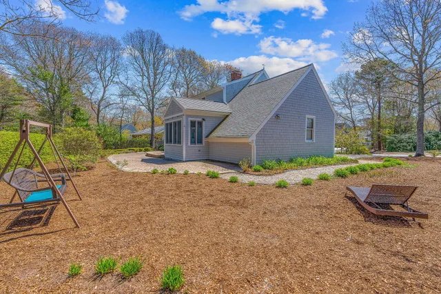 a view of a house with backyard and sitting area