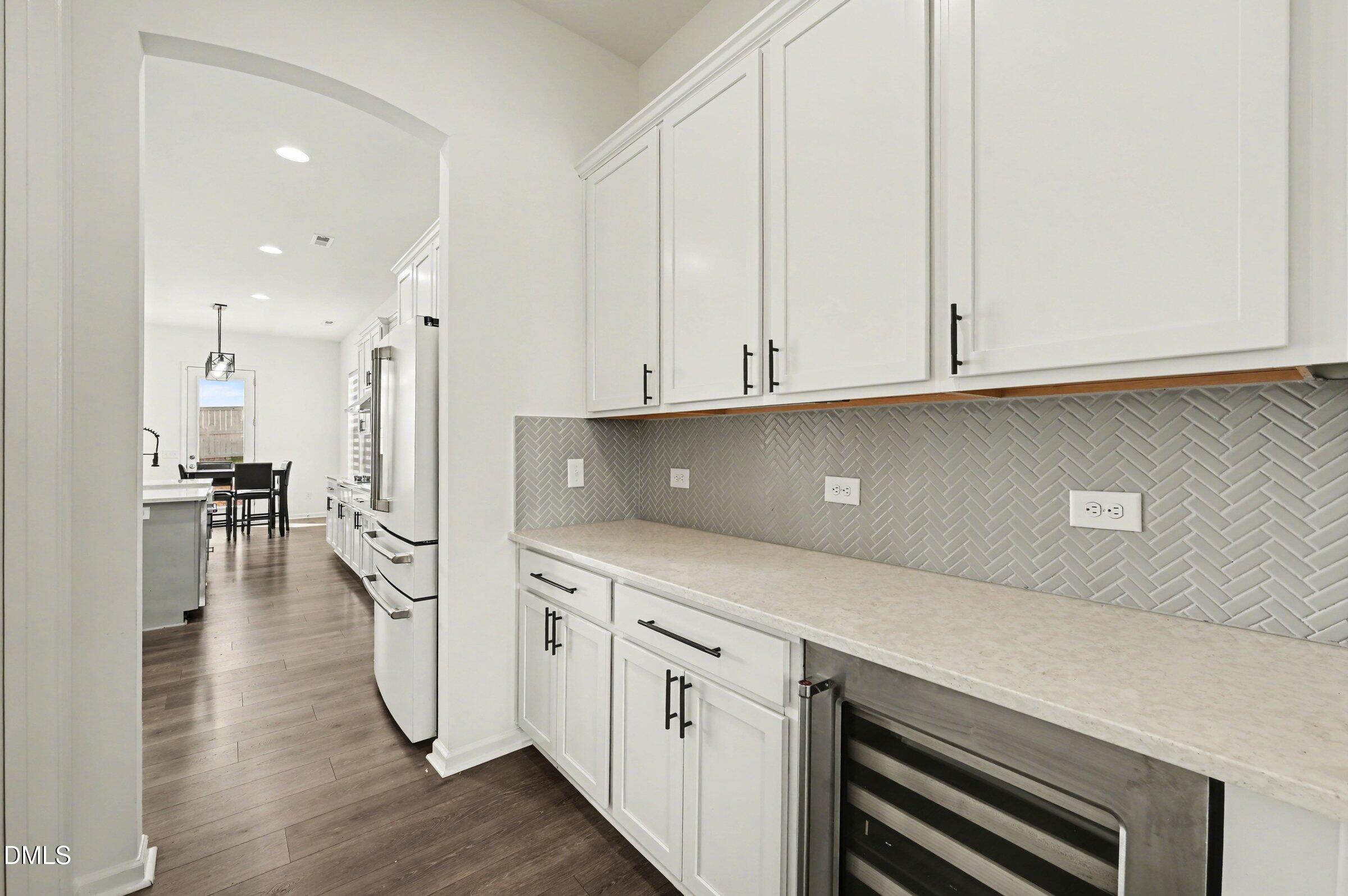 7015 Grainfield Road Mebane, NC 27302 - Photo 16 of 42 a kitchen with stainless steel appliances granite countertop a stove a sink and white cabinets with wooden floor