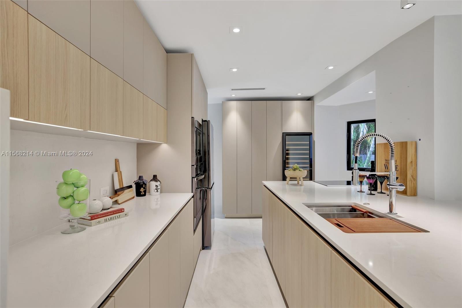 4321 Alton Road Miami Beach, FL 33140 - Photo 18 of 56 a large kitchen with stainless steel appliances a sink a counter top space and a center island