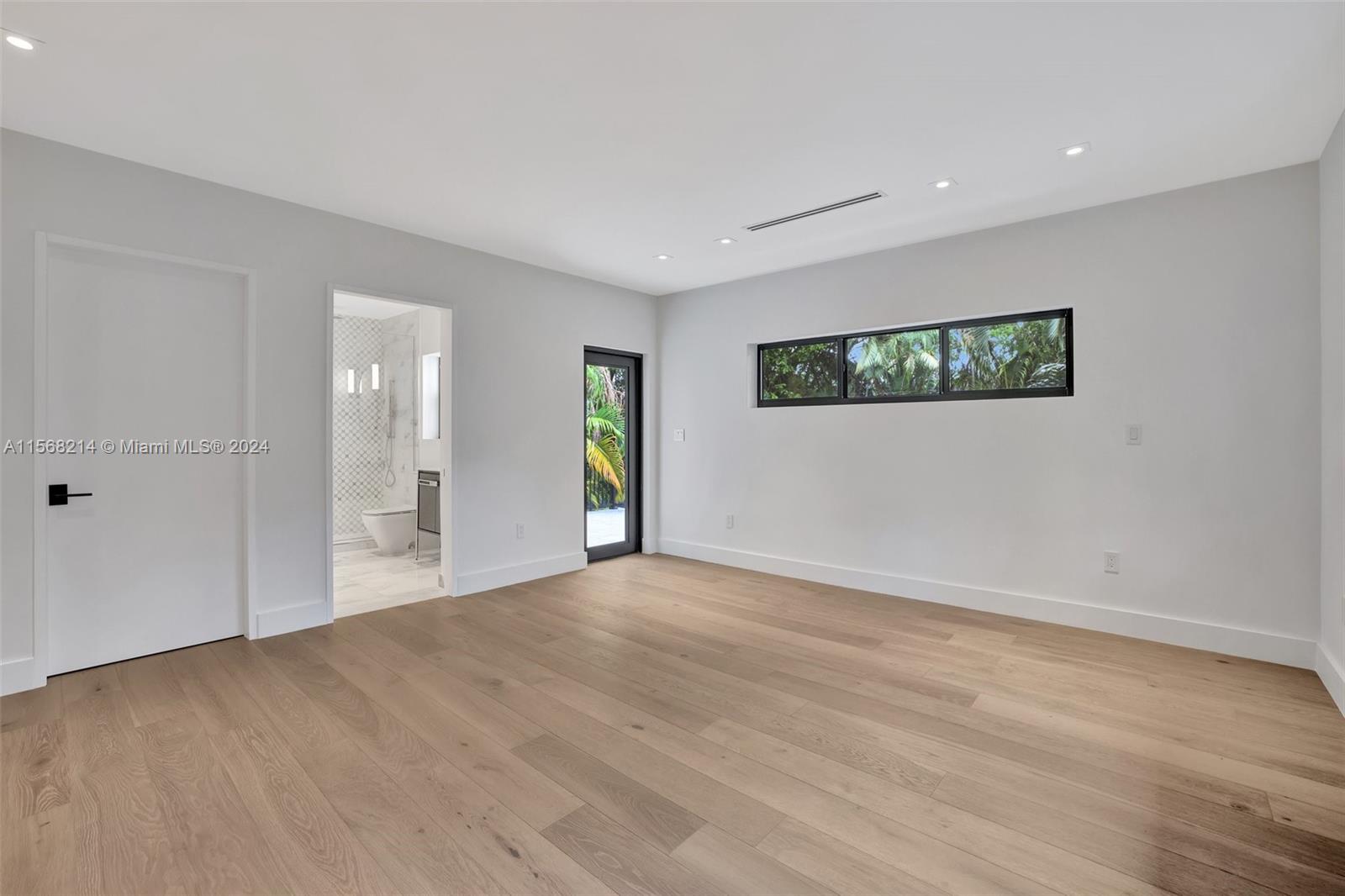 4321 Alton Road Miami Beach, FL 33140 - Photo 34 of 56 a view of an empty room with window and wooden floor
