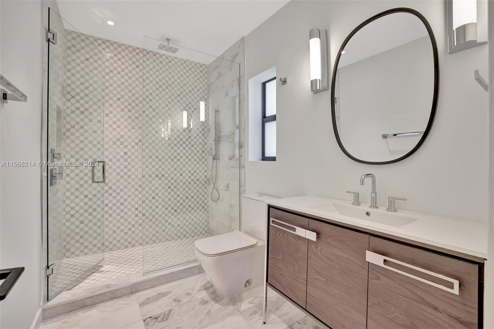 4321 Alton Road Miami Beach, FL 33140 - Photo 36 of 56 a bathroom with a sink a toilet and a mirror