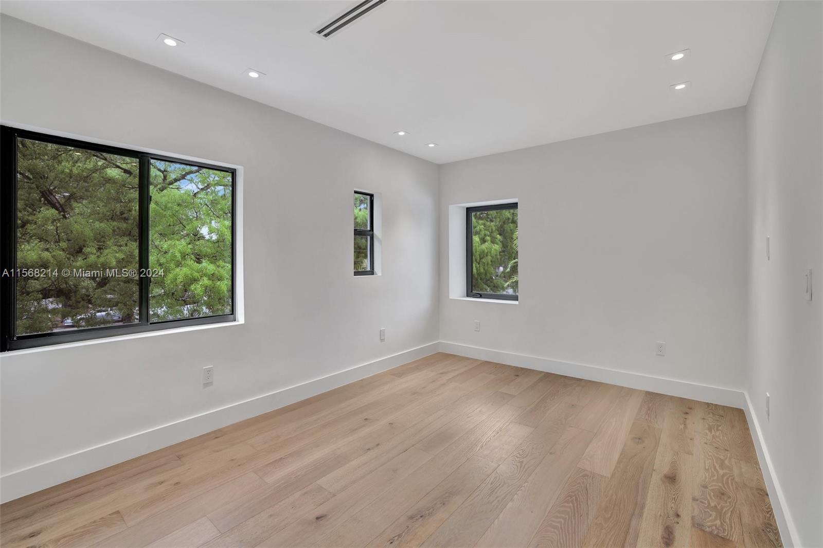 4321 Alton Road Miami Beach, FL 33140 - Photo 39 of 56 an empty room with wooden floor and windows