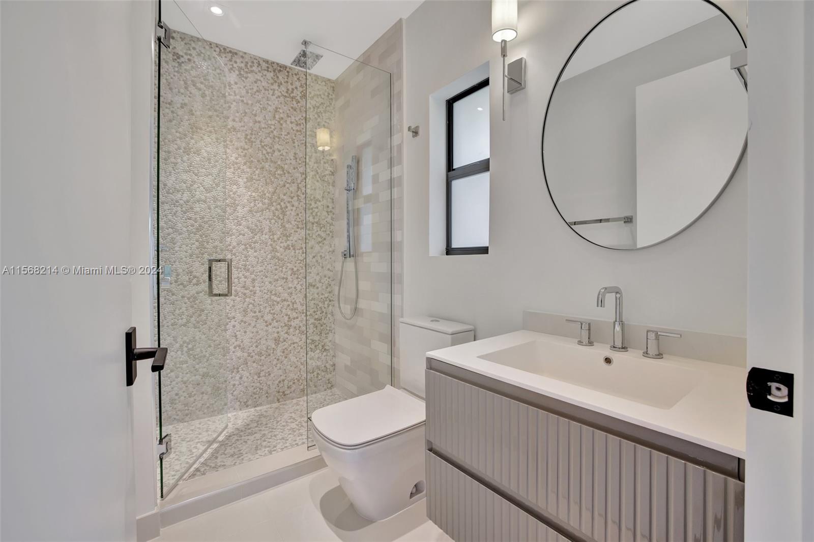 4321 Alton Road Miami Beach, FL 33140 - Photo 41 of 56 a bathroom with a sink a toilet and a mirror