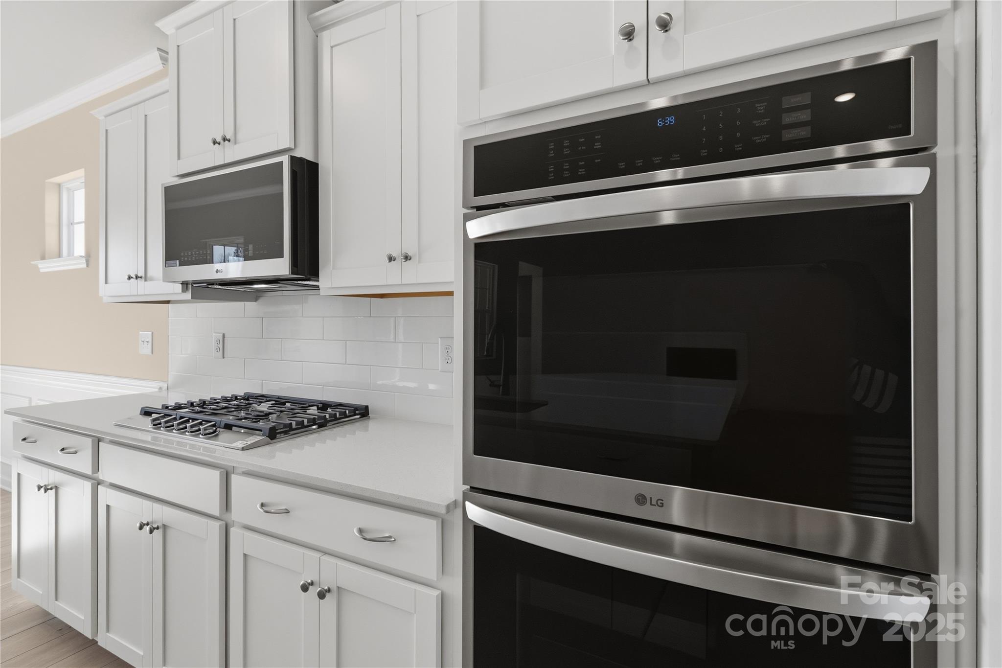 5404 Redbud Road Lancaster, SC 29720 - Photo 16 of 27 a kitchen with white cabinets and stainless steel appliances