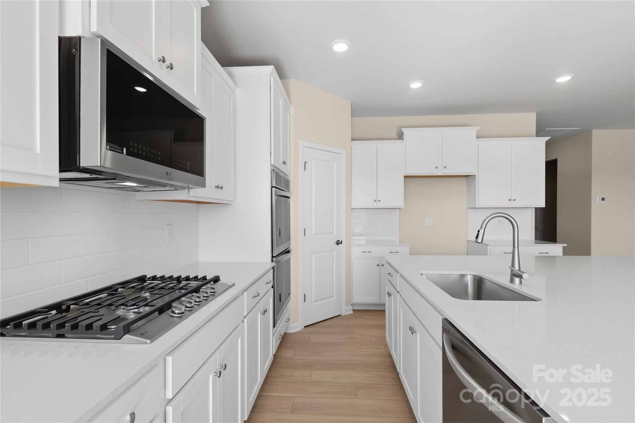 5404 Redbud Road Lancaster, SC 29720 - Photo 17 of 27 a kitchen with stainless steel appliances a stove a microwave a sink and cabinets