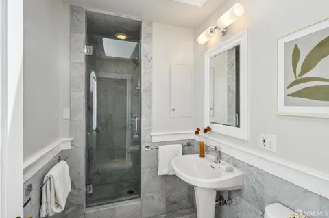 a bathroom with a sink a toilet and shower