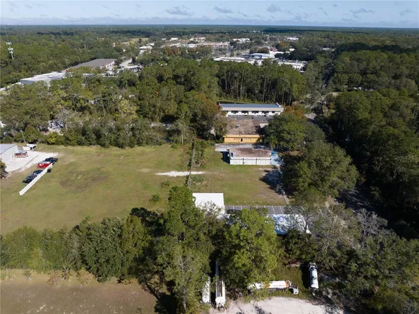 an aerial view of residential houses with outdoor space and trees