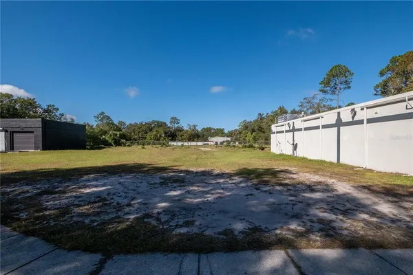 a view of a yard with yellow house