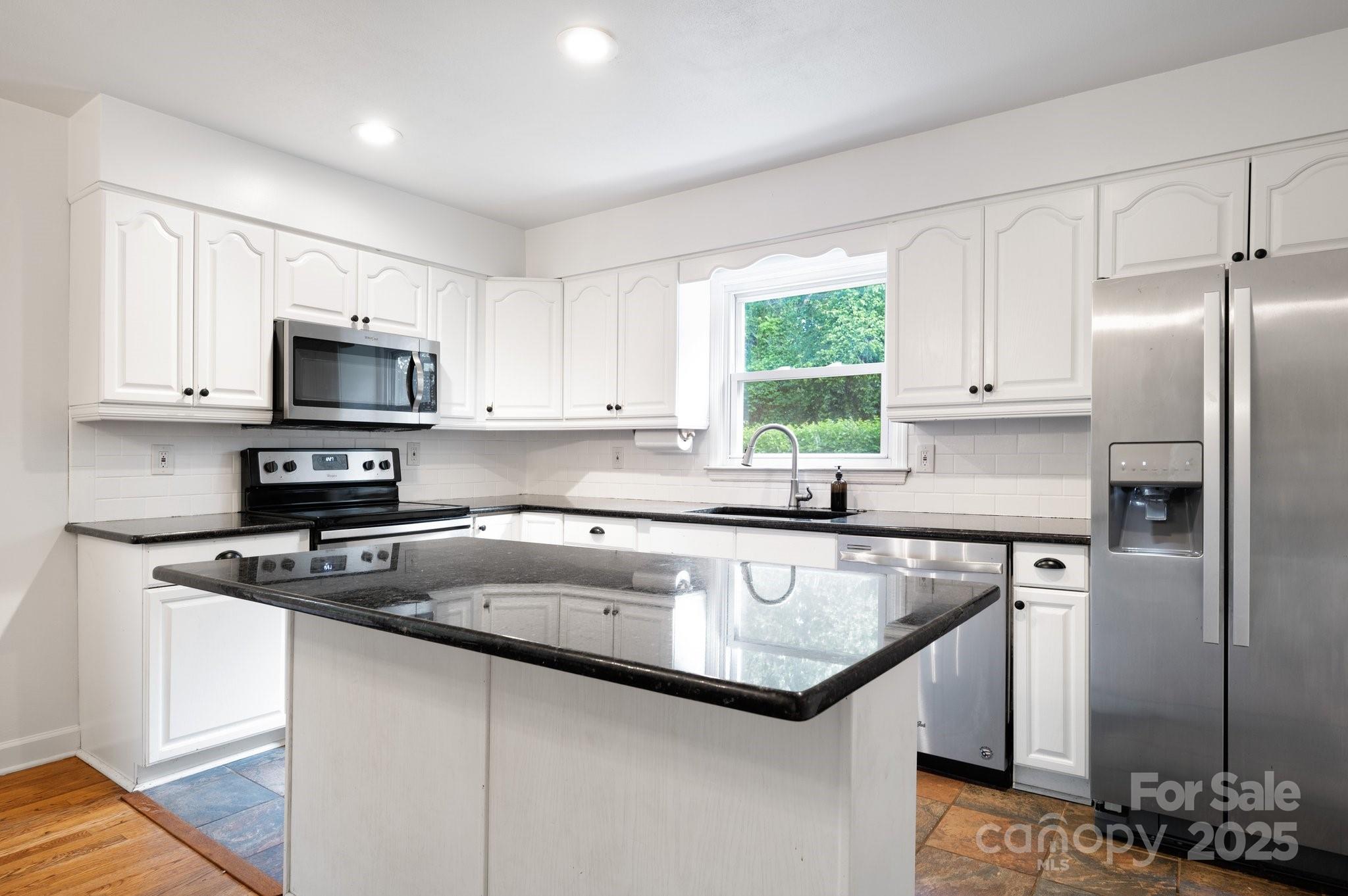 28 Spaulding Road Candler, NC 28715 - Photo 14 of 31 a kitchen with granite countertop a sink stove and refrigerator