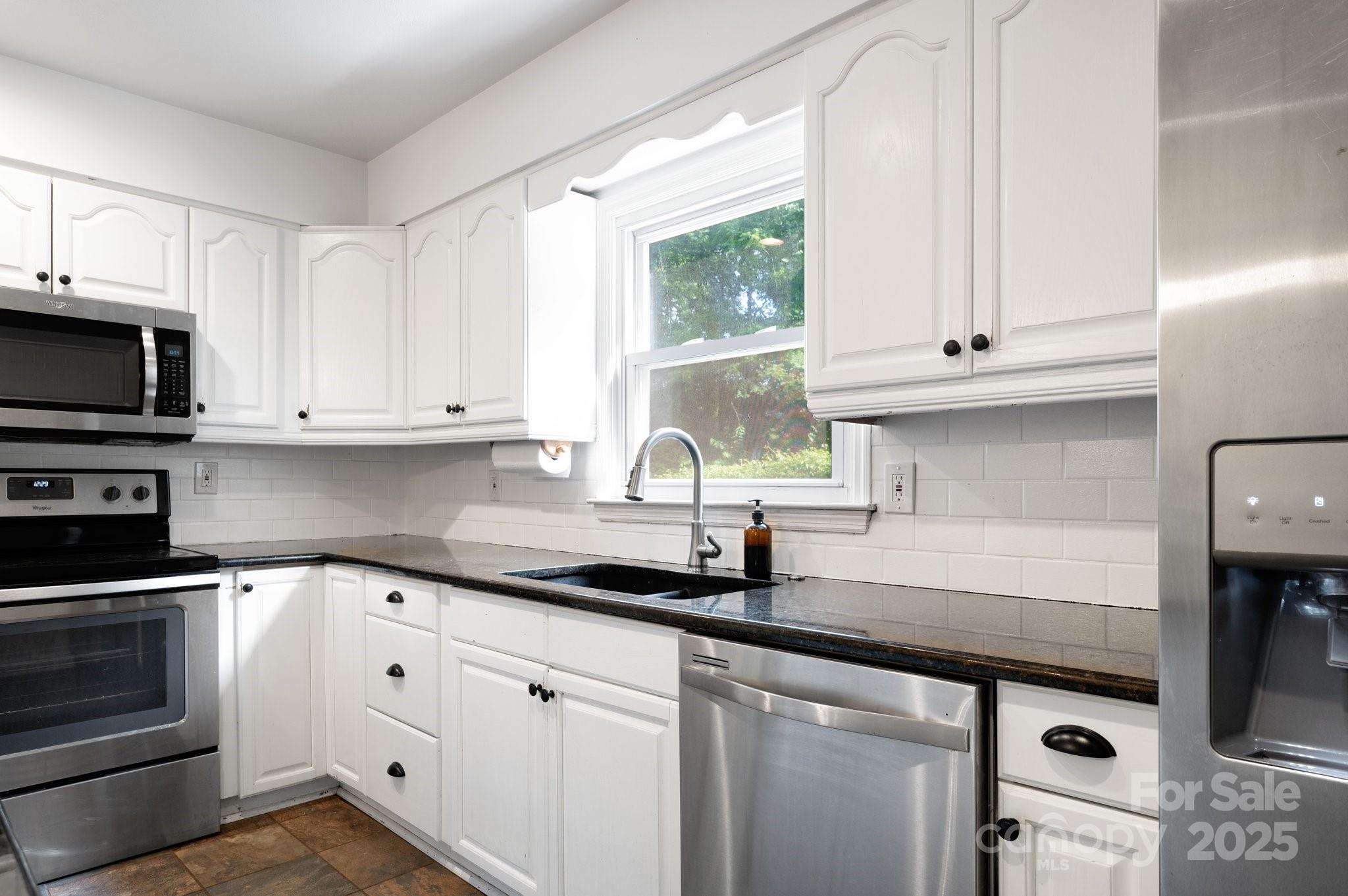 28 Spaulding Road Candler, NC 28715 - Photo 16 of 31 a kitchen with granite countertop white cabinets white stainless steel appliances and a sink