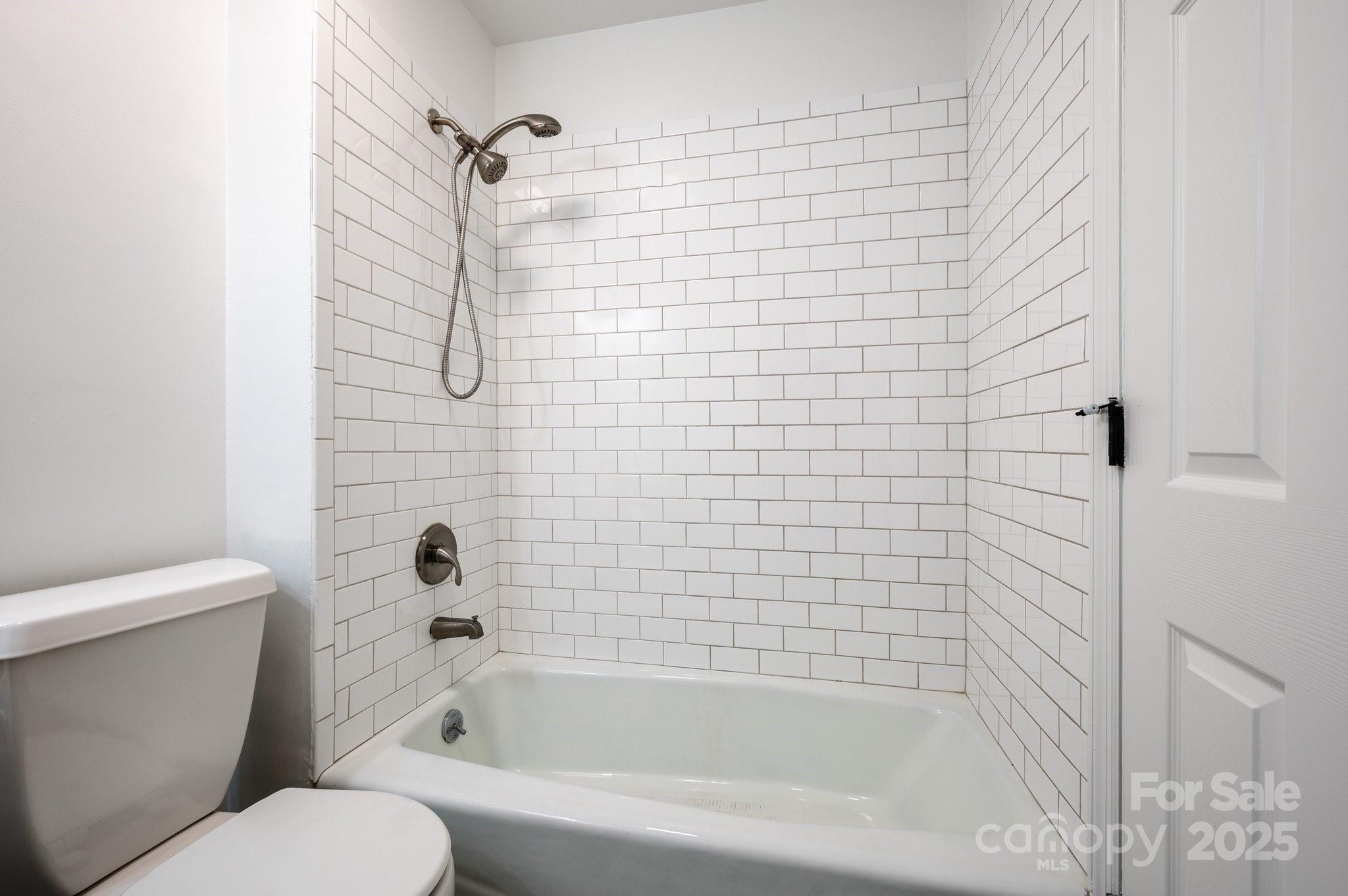 28 Spaulding Road Candler, NC 28715 - Photo 20 of 31 a bathroom with a bathtub and a toilet