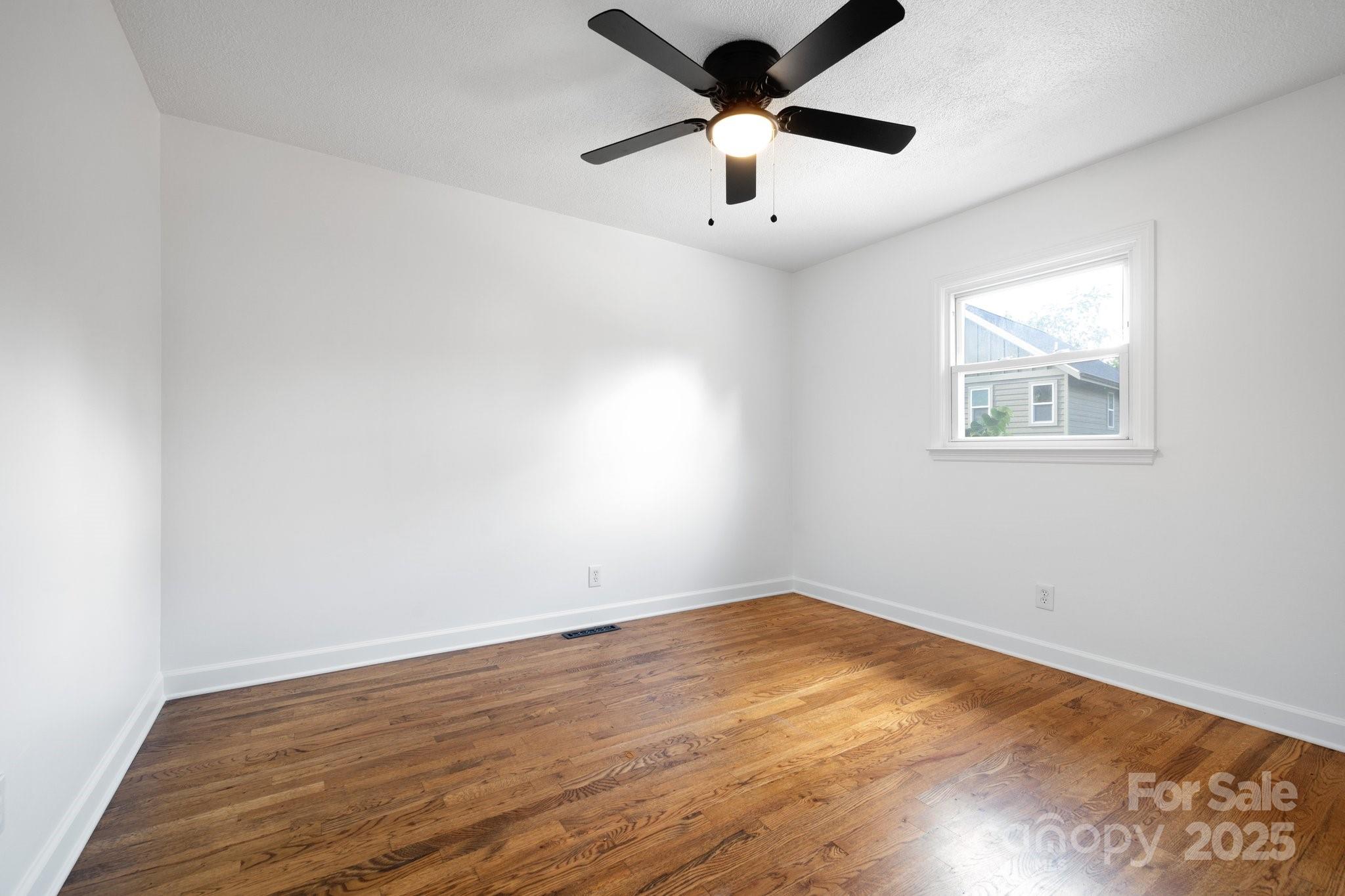 28 Spaulding Road Candler, NC 28715 - Photo 22 of 31 an empty room with wooden floor and windows