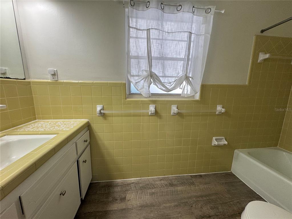 629 Rugby Street Orlando, FL 32804 - Photo 11 of 19 a bathroom with a granite countertop sink a toilet and bathtub