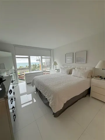 a bedroom with a large bed and a large window