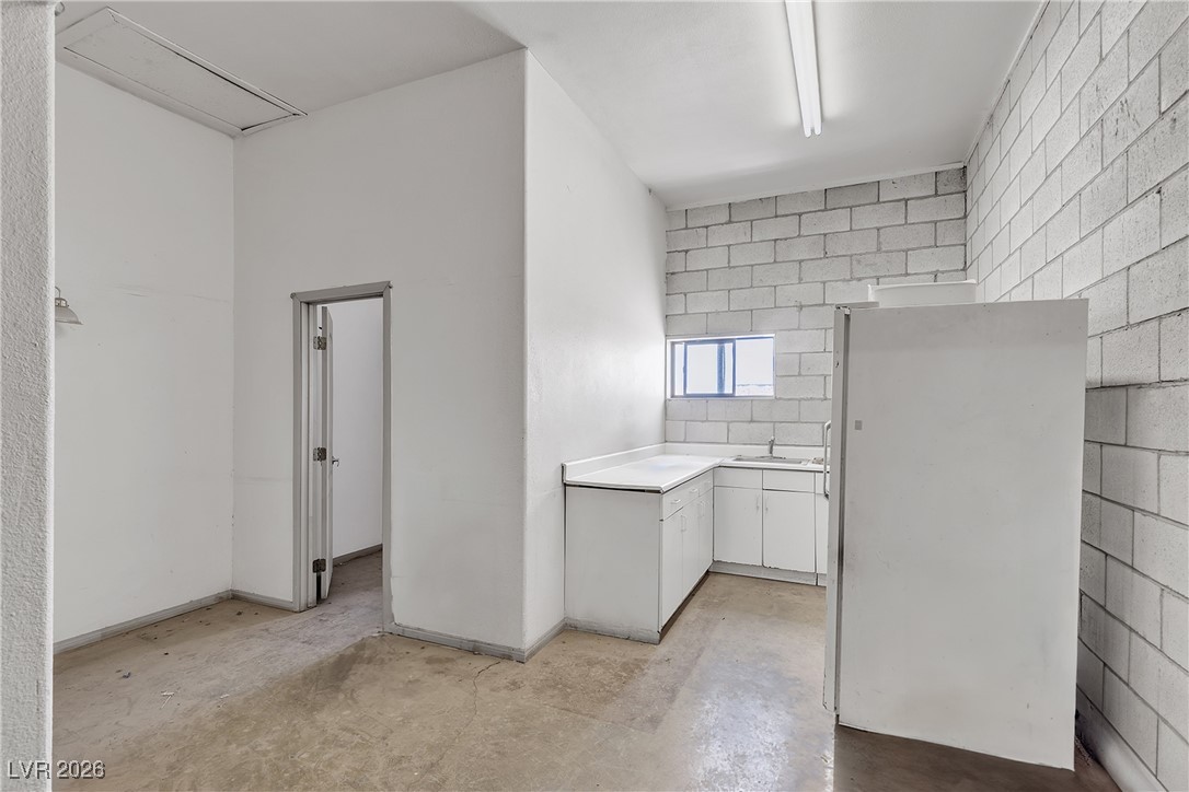 825 West Ryan Avenue Overton, NV 89040 - Photo 19 of 88 Kitchen with concrete floors, light countertops, freestanding refrigerator, and white cabinets