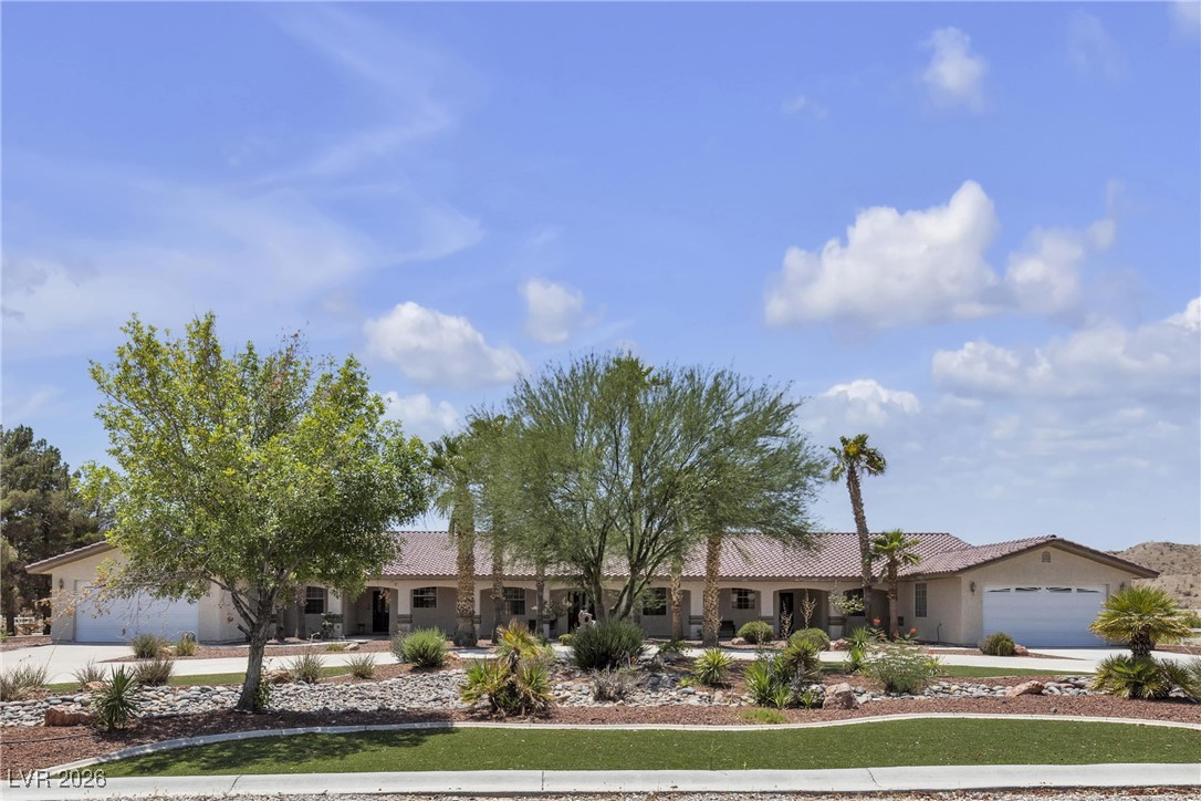 825 West Ryan Avenue Overton, NV 89040 - Photo 2 of 88 Ranch-style home featuring driveway, a garage, a tiled roof, and stucco siding