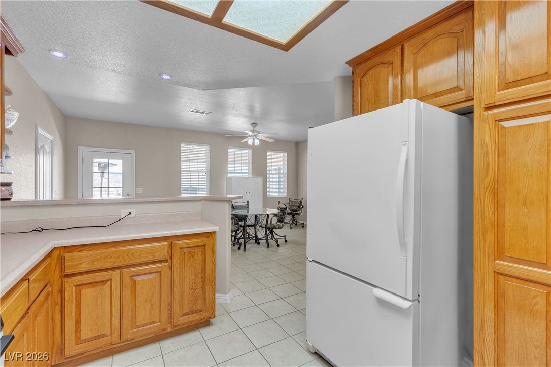 825 West Ryan Avenue Overton, NV 89040 - Photo 53 of 88 Kitchen featuring freestanding refrigerator, ceiling fan, light tile patterned floors, plenty of natural light, and recessed lighting