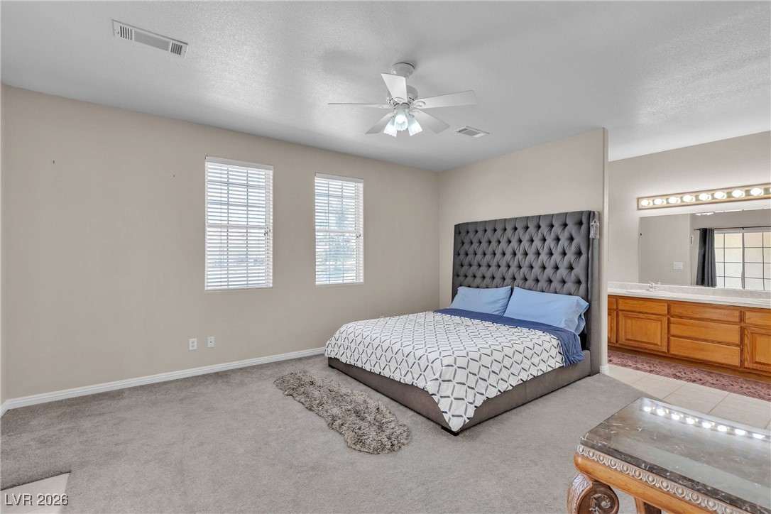 825 West Ryan Avenue Overton, NV 89040 - Photo 57 of 88 Bedroom with light carpet, connected bathroom, and ceiling fan