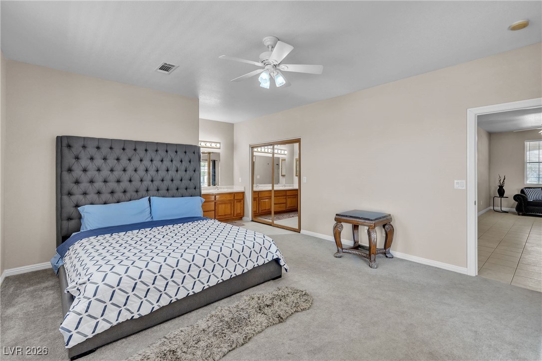 825 West Ryan Avenue Overton, NV 89040 - Photo 58 of 88 Bedroom with light colored carpet, a ceiling fan, and ensuite bathroom