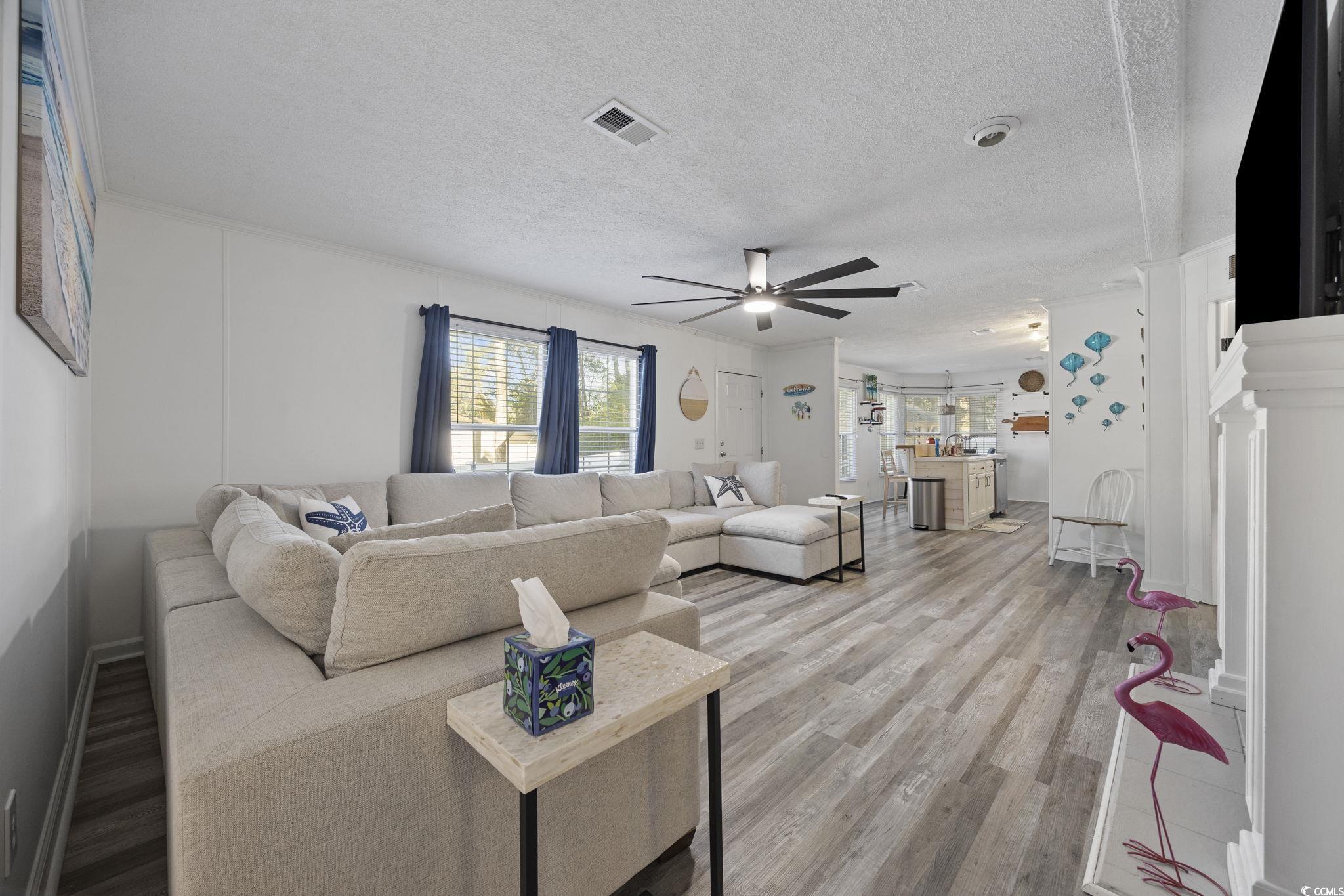 944 Pine Thicket Street Myrtle Beach, SC 29577 - Photo 2 of 27 Living area with a textured ceiling, light wood-style floors, and a ceiling fan