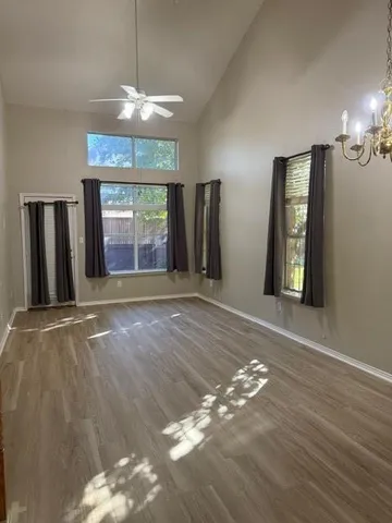 an empty room with windows and fireplace