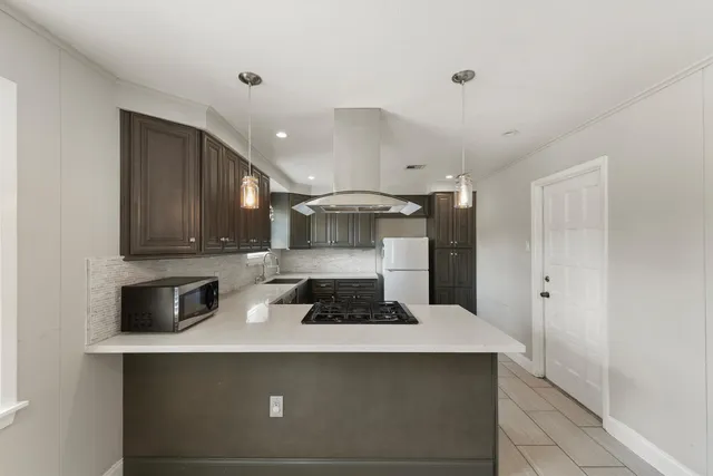 a kitchen with stainless steel appliances a stove a sink and white cabinets