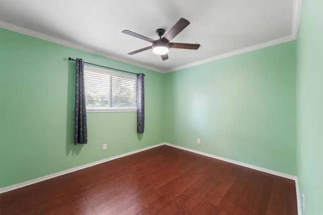 an empty room with window and ceiling fan