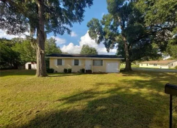 a front view of house with yard and trees