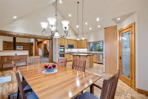a view of a dining room and livingroom with furniture wooden floor a chandelier