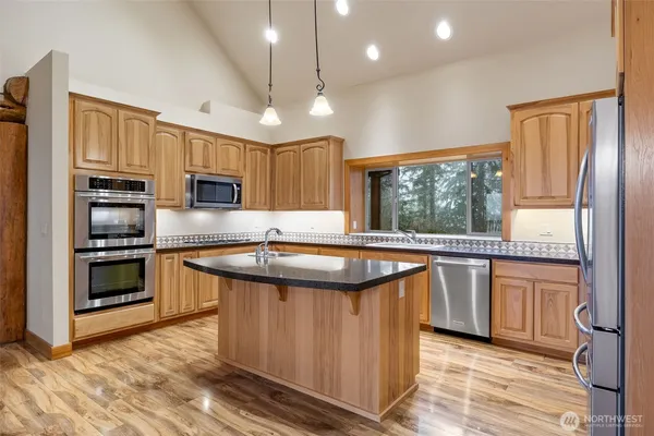 a kitchen with stainless steel appliances granite countertop refrigerator a stove a sink and a microwave